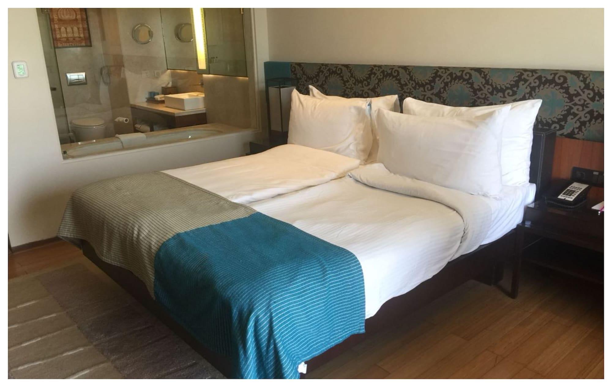 Vivanta Surajkund, NCR Faridabad Buitenkant foto A bed with a throw